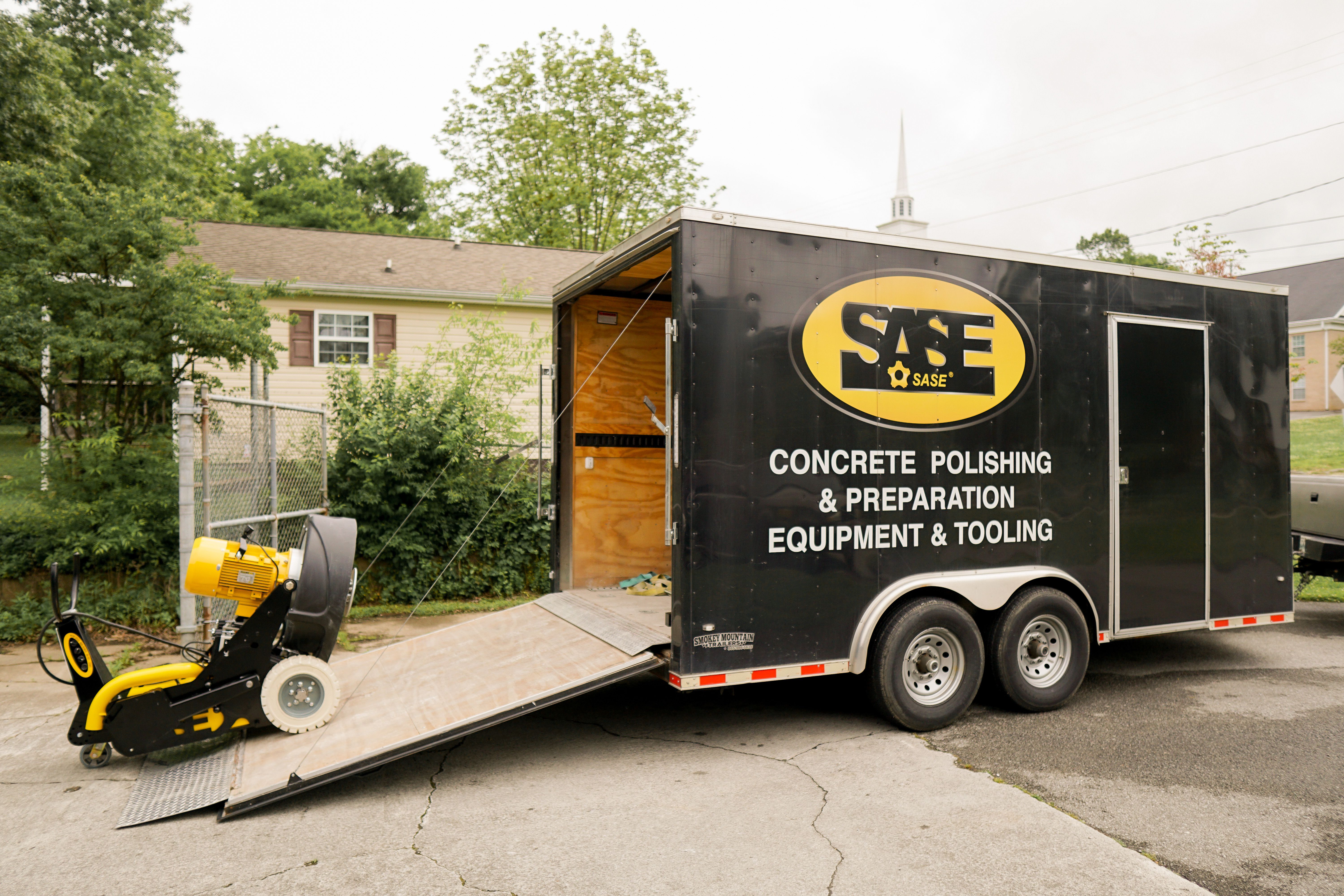 Driving the concrete grinder in transport position up a ramp into SASE's trailer