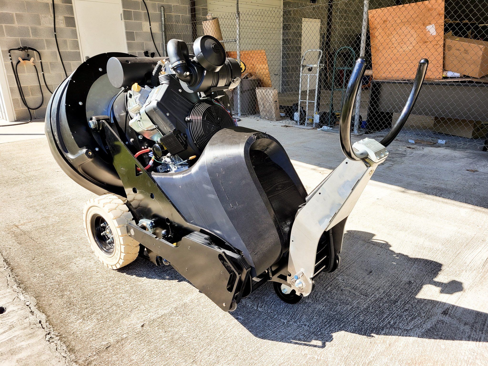 The SASE 8KR grinder prototype parked outside, showing its engine, wheels, and handlebar, during a test of the transport drive setup