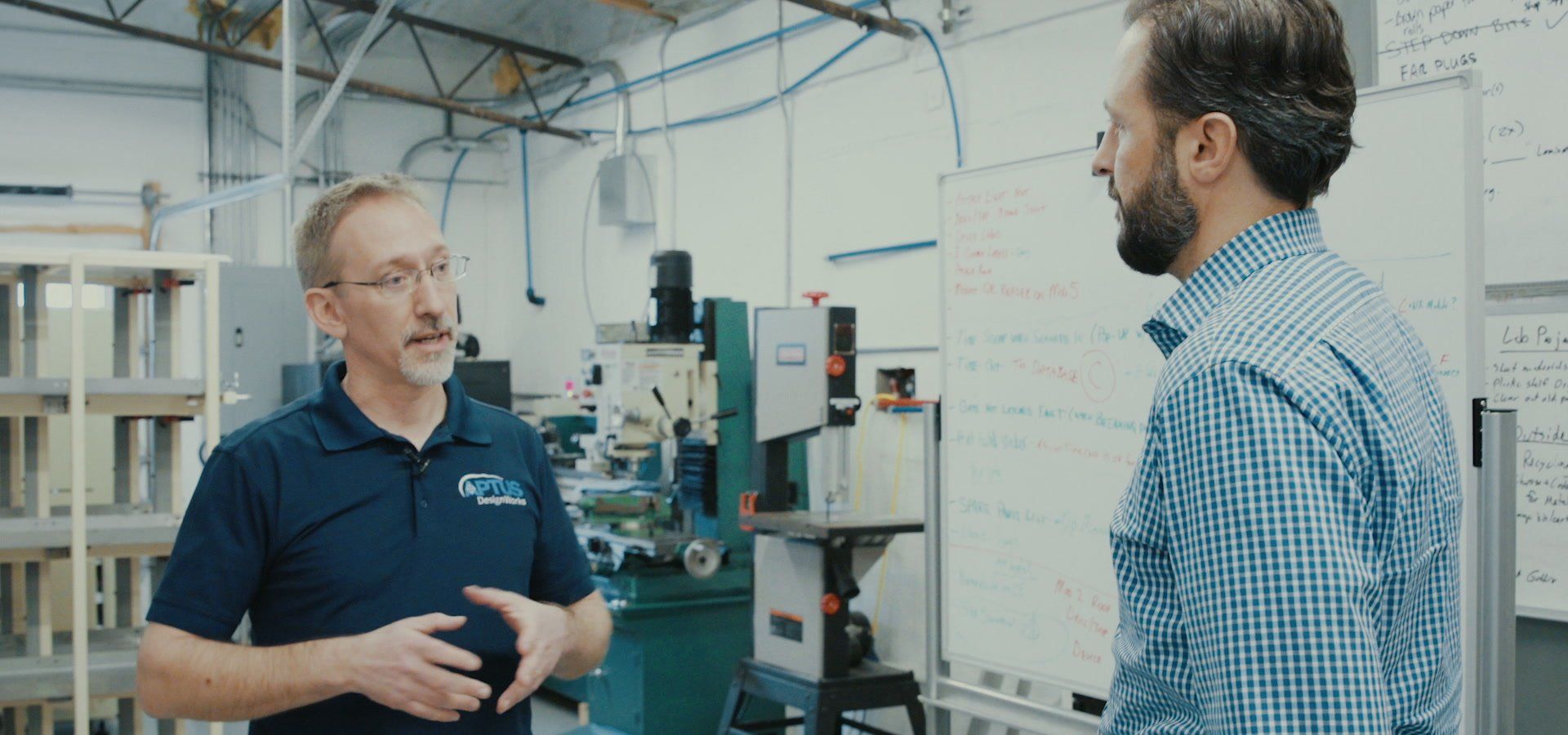Two APTUS engineers discussing a project on the shop floor