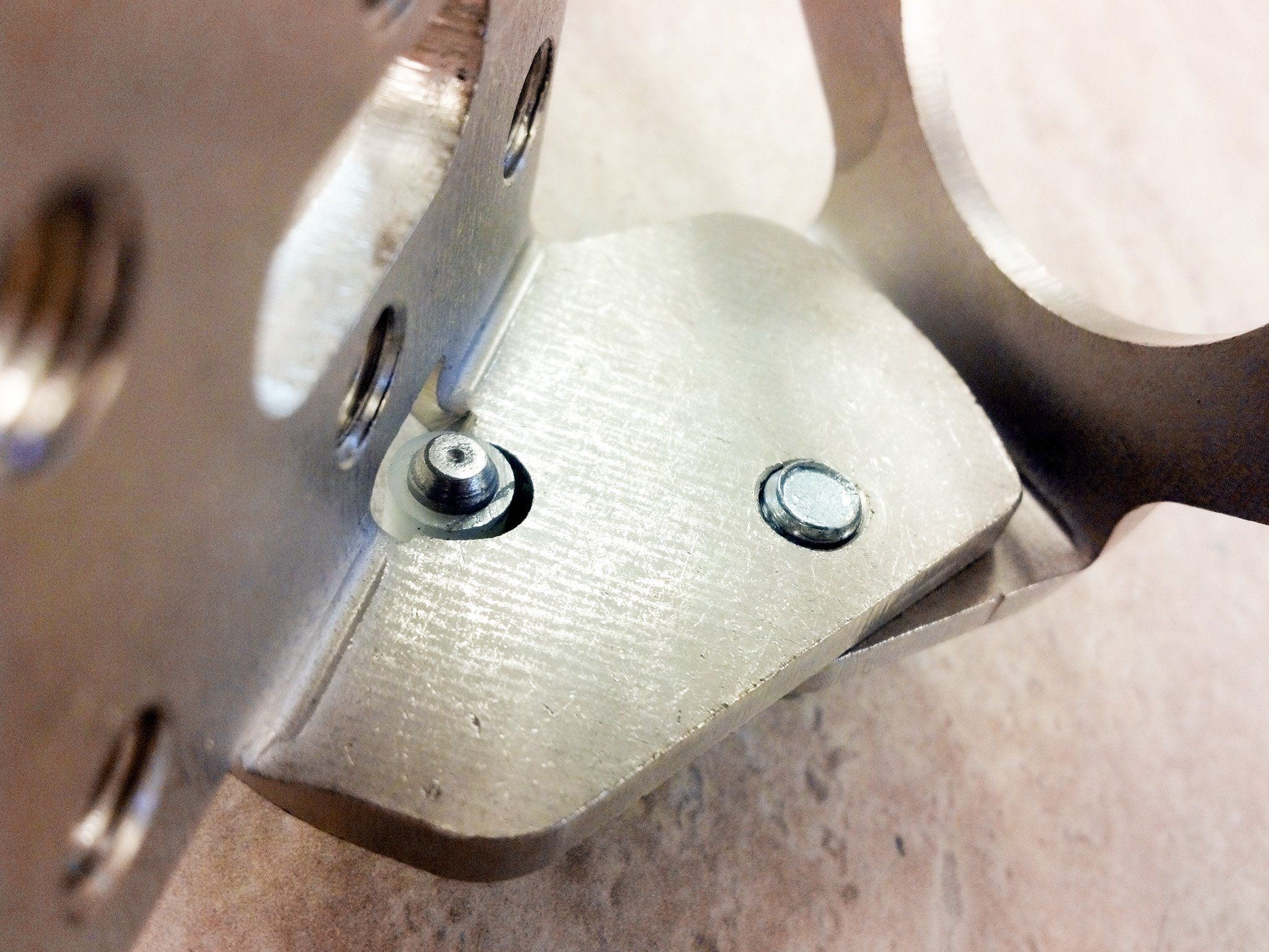 Close-up of the machined bracket’s pivot and mounting holes