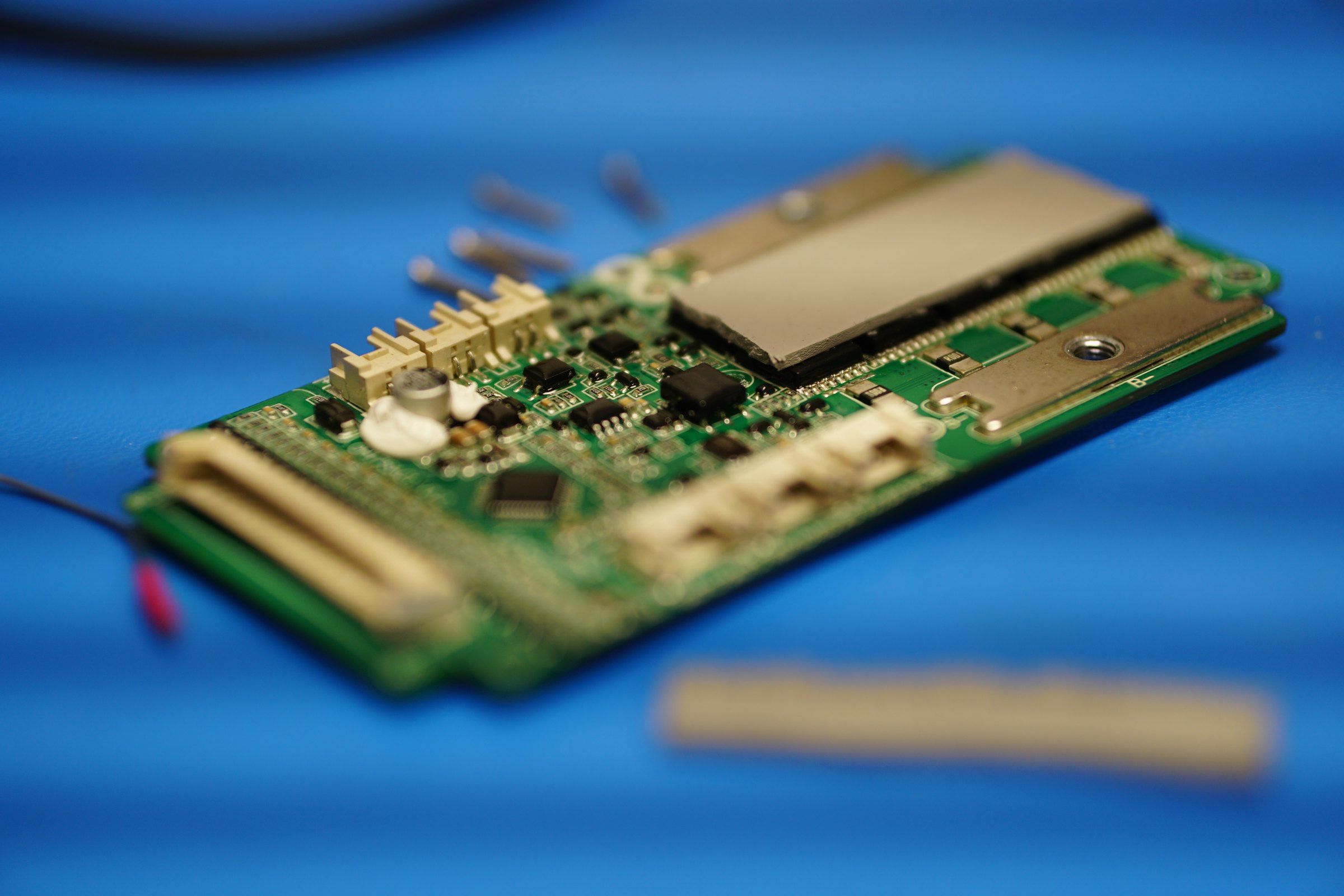 A circuit board from an APTUS prototype on a blue work surface