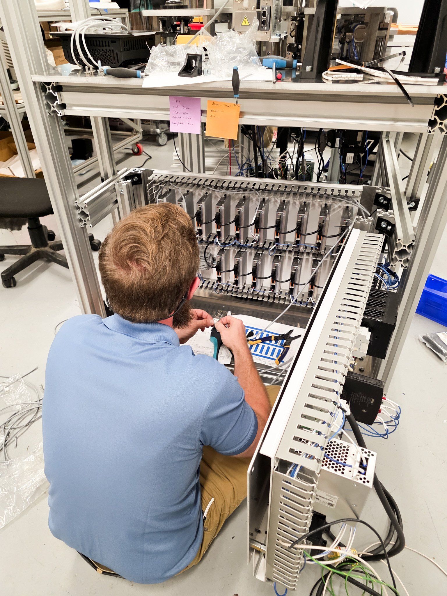 An APTUS technician wiring the mixing machine's control panel