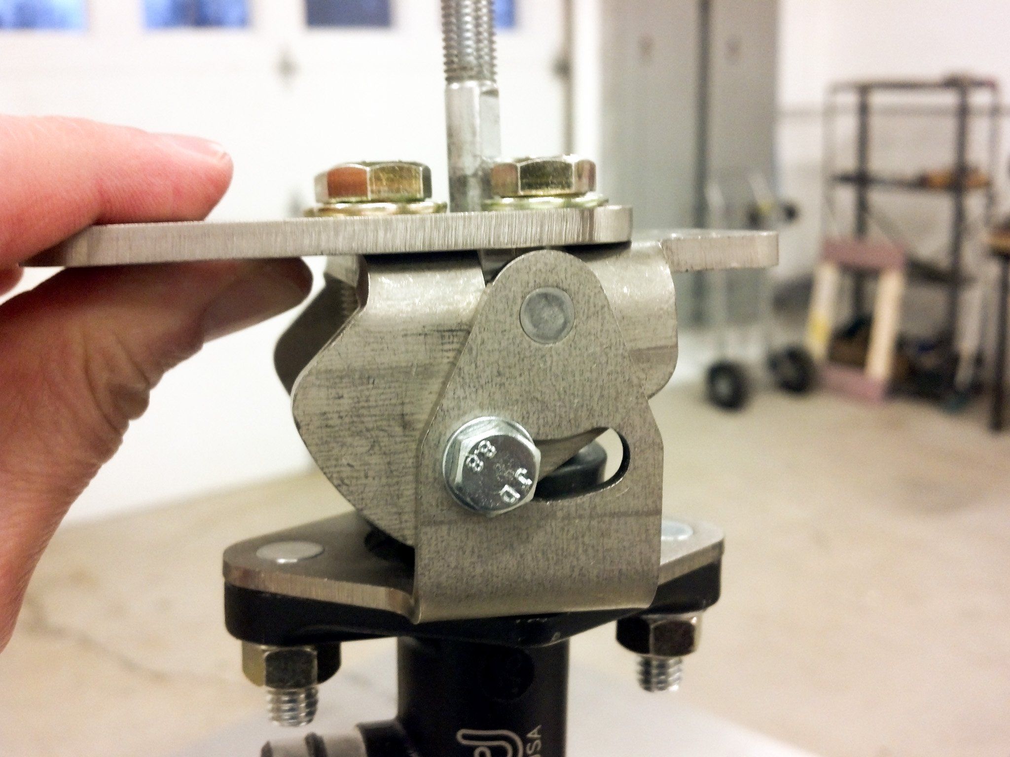 A hand holding the Hydramax bracket and master cylinder assembly