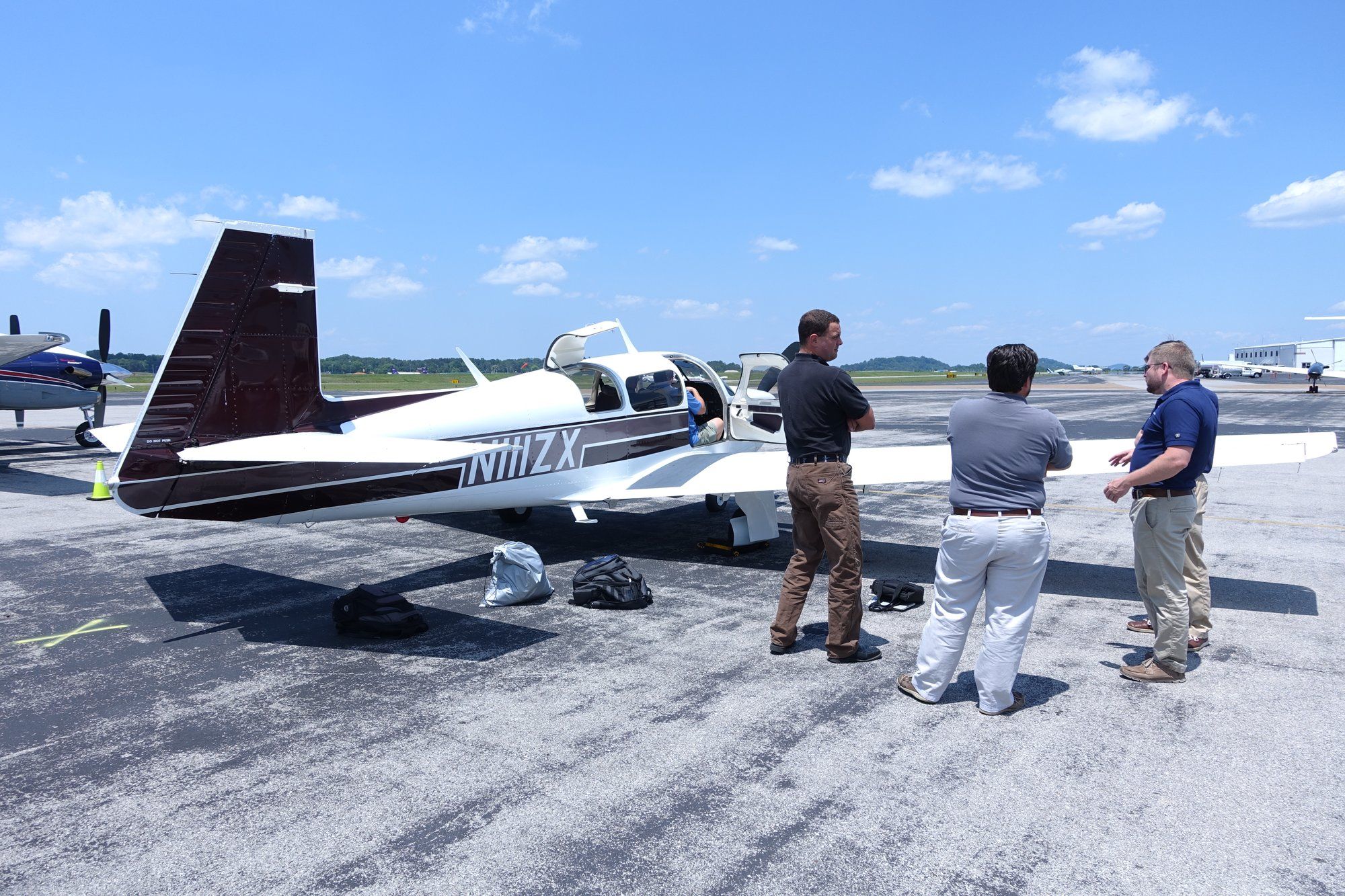 APTUS team members beside the company plane on the tarmac before a customer visit